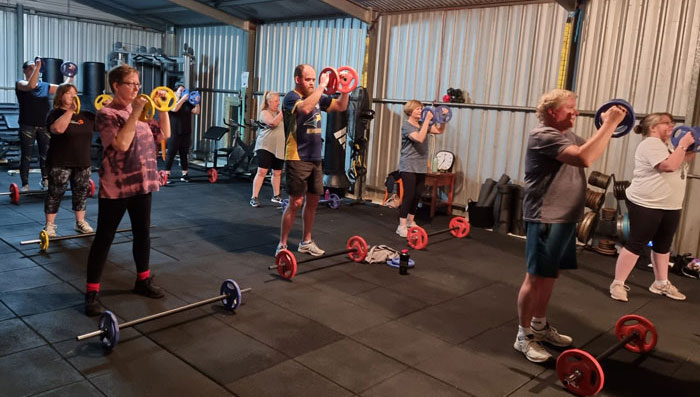 Clients lifting barbell weights in our lifted class.