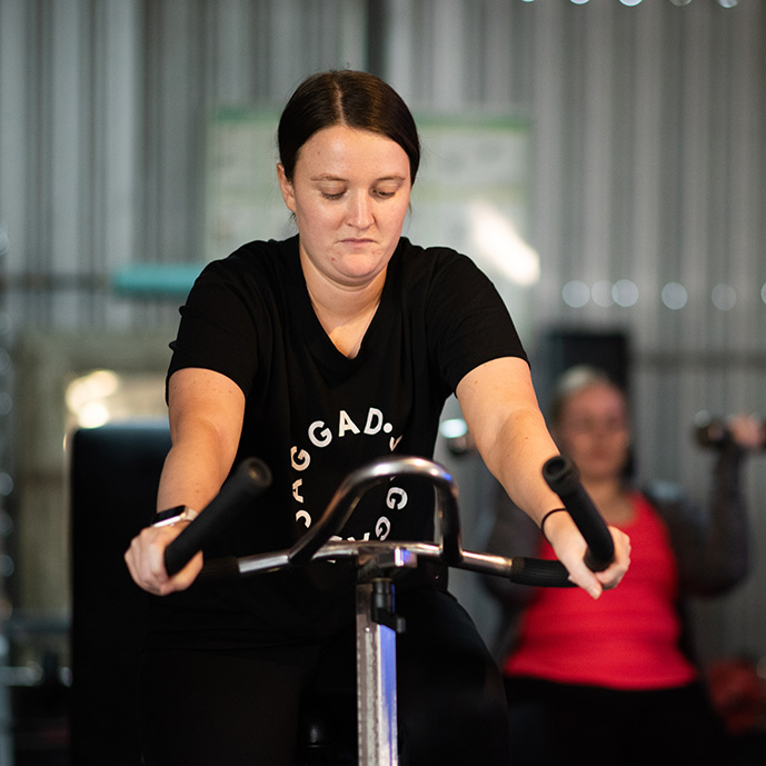 Girl on the stationary bike for a pedal x class.