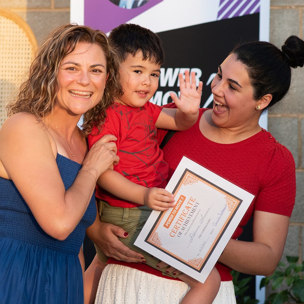 Trainer posing with mother and young son after awarding them 'comeback kid' certificate.