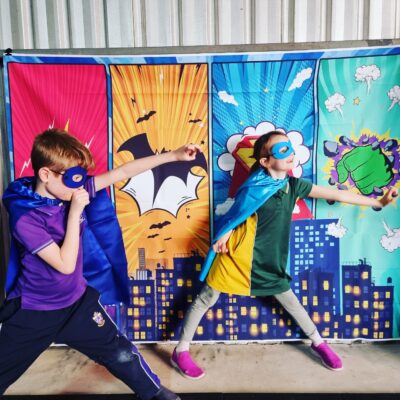 Two kids dressed in superhero masks and capes in the superkids fitness program