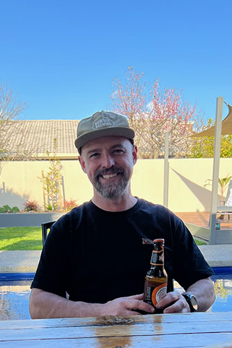 Our trainer Andrew sitting outside in the sun enjoying a beer.